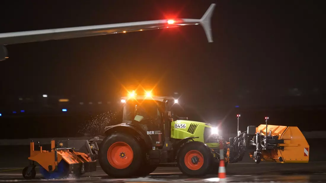 Ein Räumfahrzeug fährt über das Flugfeld des Berliner Flughafen BER. - Bild: Michael Bahlo/dpa