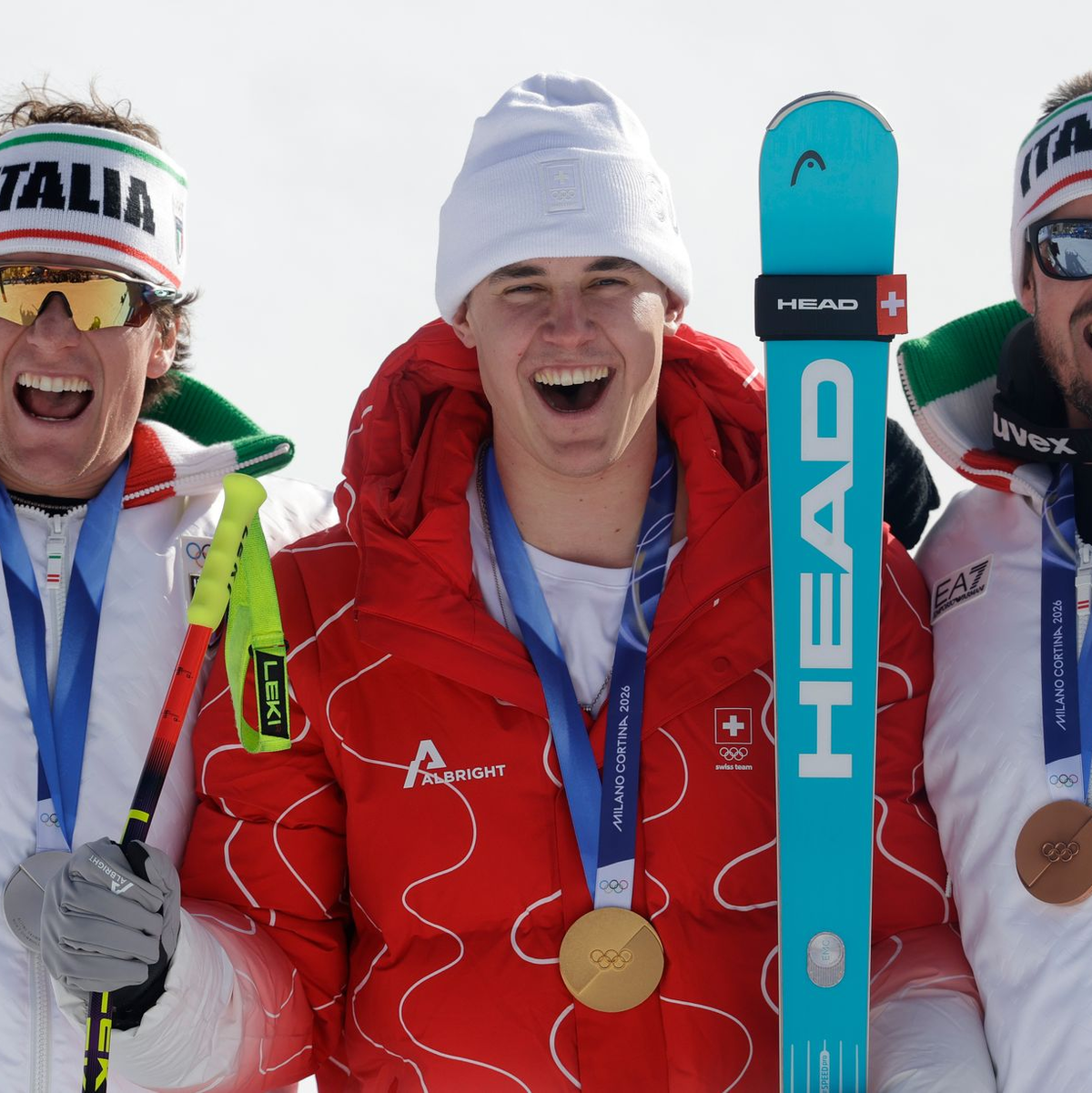 Olympiasieger Franjo von Allmen wird flankiert von Silber-Gewinner Giovanni Franzoni (links) und dem Drittplatzierten Dominik Paris. - Foto: Oliver Weiken/dpa