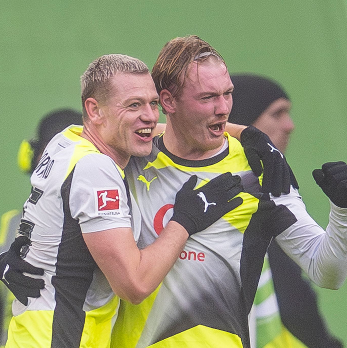 Julian Brandt (r) jubelt mit Julian Ryerson über seinen Treffer. - Foto: David Inderlied/dpa