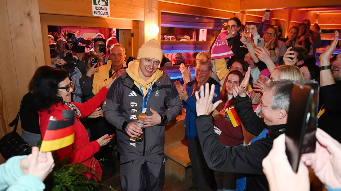 Feierlicher Empfang: Langenhan läuft mit seiner Goldmedaille ins Deutsche Haus ein. - Bild: Frank May/ picture alliance/Team D/dpa