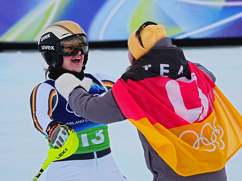 Emma Aicher (links) und Kira Weidle-Winkelmann jubeln über Olympia-Silber in der Team-Kombination. - Foto: Michael Kappeler/dpa