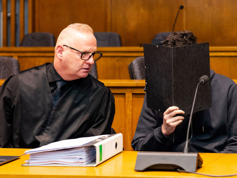 Der wegen Mordes angeklagte junge Mann sitzt neben seinem Verteidiger Michael Rehberger im Landgericht Saarbrücken. - Foto: Laszlo Pinter/dpa