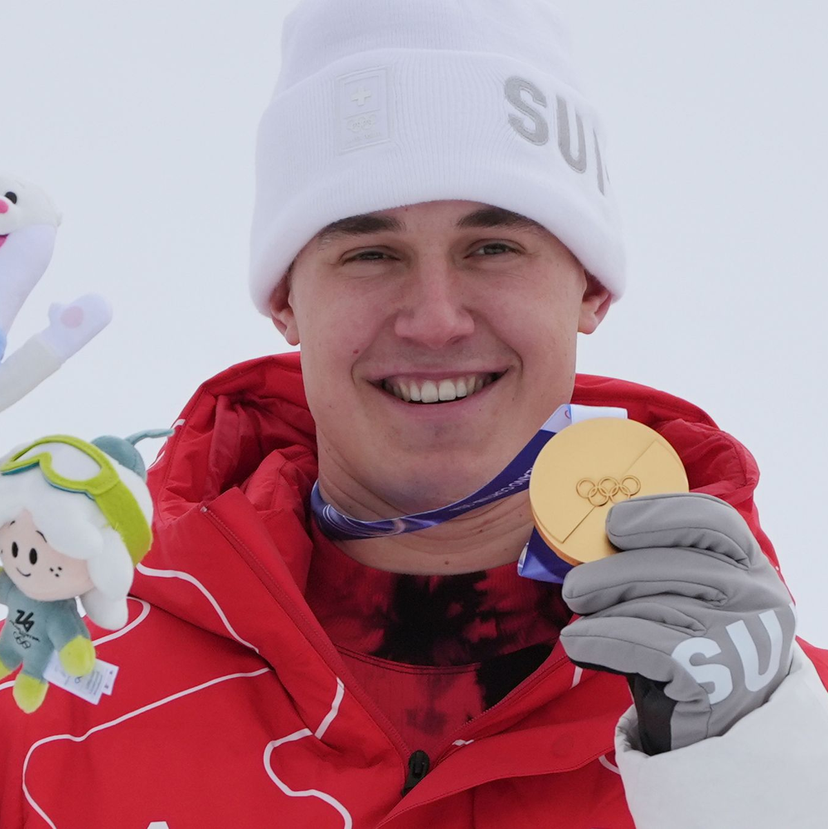 Franjo von Allmen zeigt eine seiner drei olympischen Goldmedaillen. - Foto: Rebecca Blackwell/AP/dpa