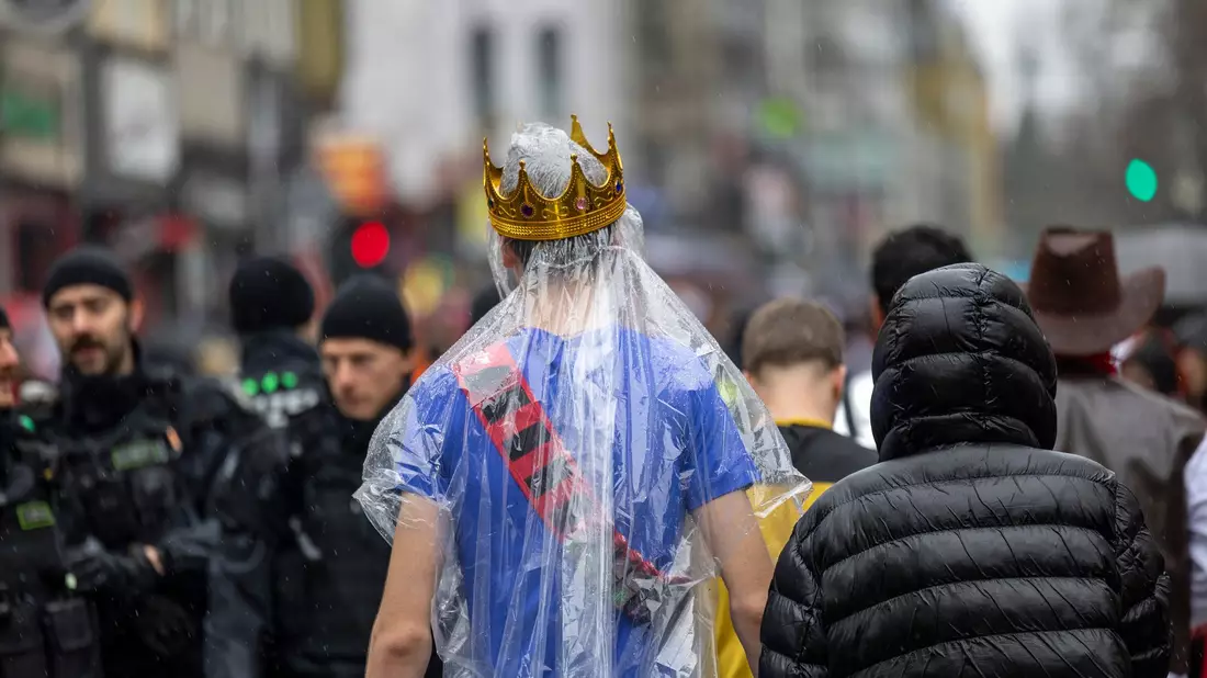 Regencape mit Krone: Die rheinischen Narren mussten an Weiberfastnacht tapfer sein. - Bild: Thomas Banneyer/dpa