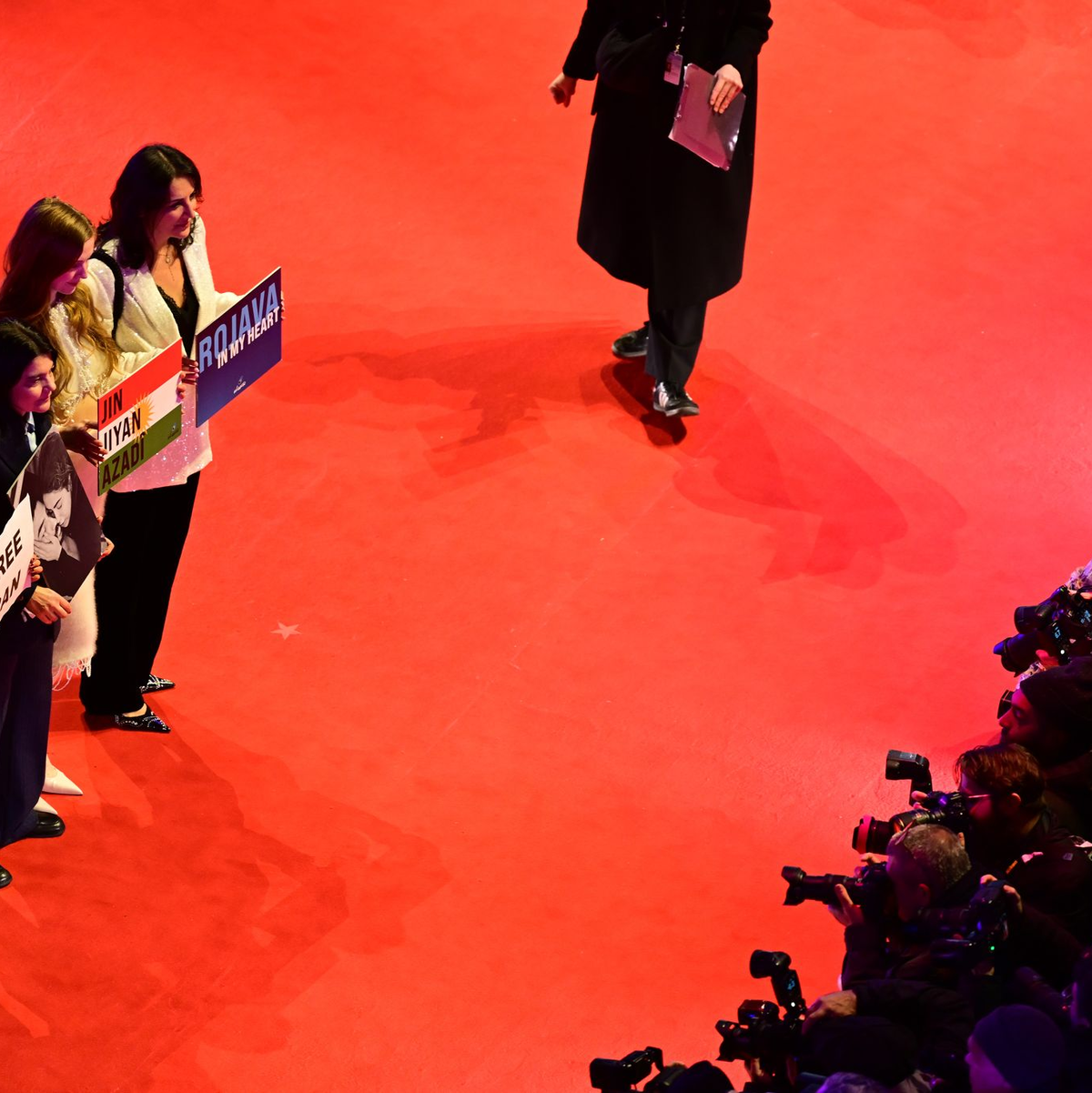 Gäste, darunter die deutsch-iranische Schauspielerin Jasmin Tabatabai (2. v. l.), halten Protestschilder hoch. - Foto: Sebastian Christoph Gollnow/dpa