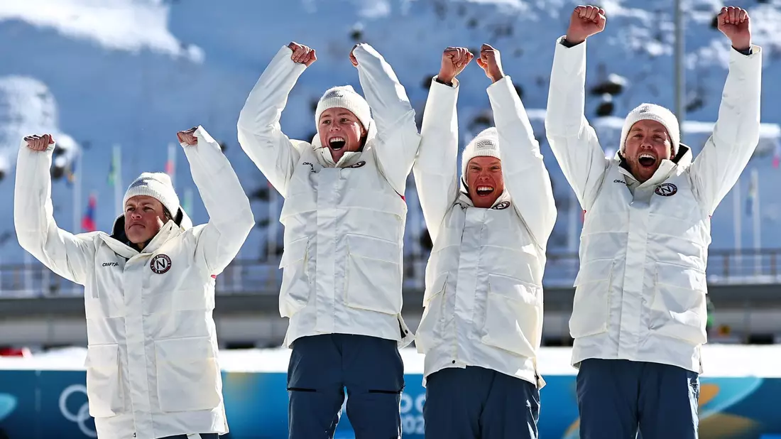 Johannes Hoesflot Klaebo (l) jubelt mit dem Team. - Bild: Daniel Karmann/dpa