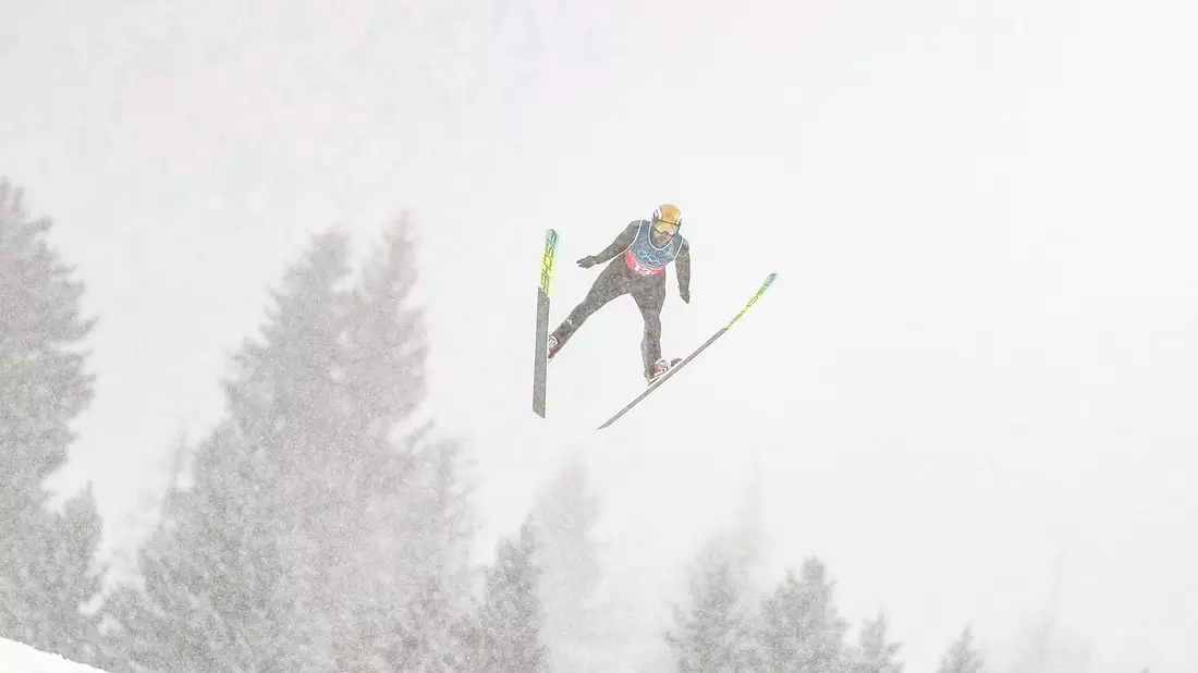 Johannes Rydzek und seine Kollegen sprangen bei starkem Schneefall. - Bild: Matthias Schrader/AP/dpa