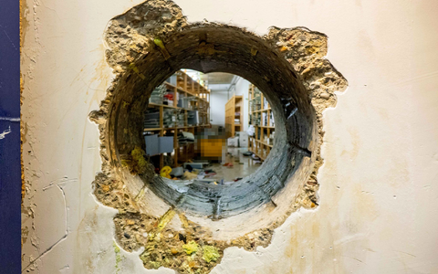 Durch dieses Loch kamen die Einbrecher in den Tresorraum - Foto: -/Polizei Gelsenkirchen/dpa