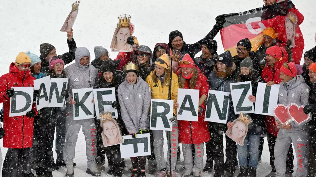 Im Ziel wartete das Team mit einer Botschaft auf Franziska Preuß. - Bild: Hendrik Schmidt/dpa