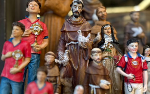 Figuren des alten und des neuen Heiligen stehen in Souvenirshops nebeneinander. (Archivbild) - Foto: Christoph Sator/dpa