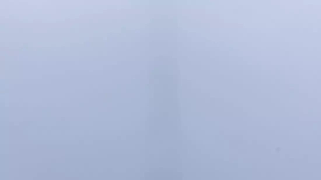 Die zahlreichen Schaulustigen konnten allerdings nur einen Teil des Spektakels sehen, denn die obere Hälfte des Schornsteins war von Nebel und Wolken verdeckt. - Bild: David Ebener/dpa