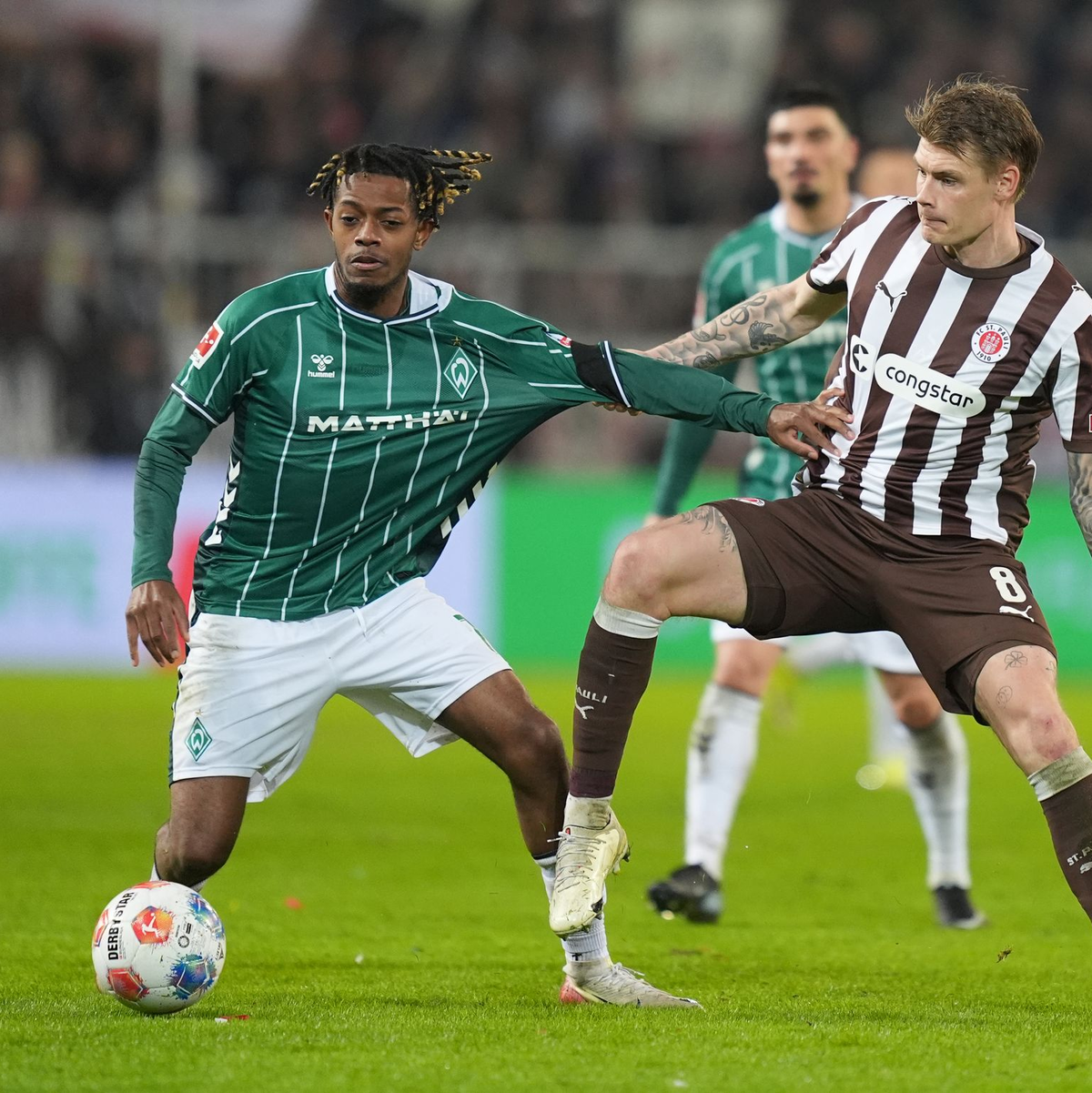 St. Paulis Eric Smith (r) kommt gegen den Bremer Samuel Mbangula zu spät. - Foto: Marcus Brandt/dpa