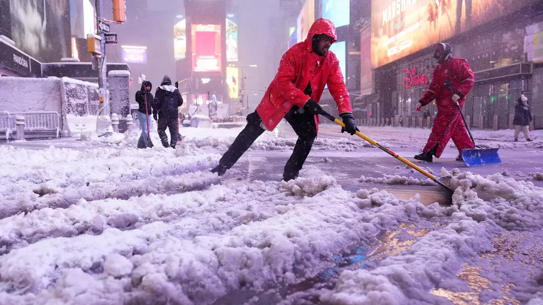 Ein Arbeiter schaufelt Schnee auf dem Times Square in New York. Ein heftiger Schneesturm zieht über den Nordosten der USA hinweg. - Bild: Seth Wenig/AP/dpa