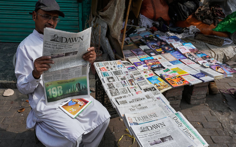 Ein Pakistaner liest an einem Verkaufsstand eine Morgenzeitung, die über die nächtlichen grenzüberschreitenden Kämpfe zwischen pakistanischen und afghanischen Streitkräften berichtet. - Foto: K.M. Chaduary/AP/dpa