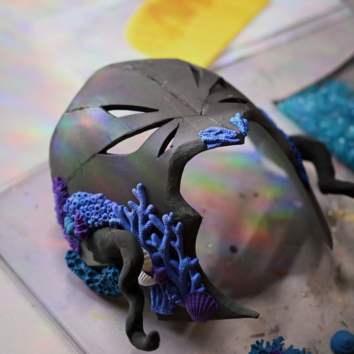 Neben ihrem aktuellen Kostüm arbeitet sie an einer Maske aus Foam Clay.  - Foto: Jennifer Brückner/dpa