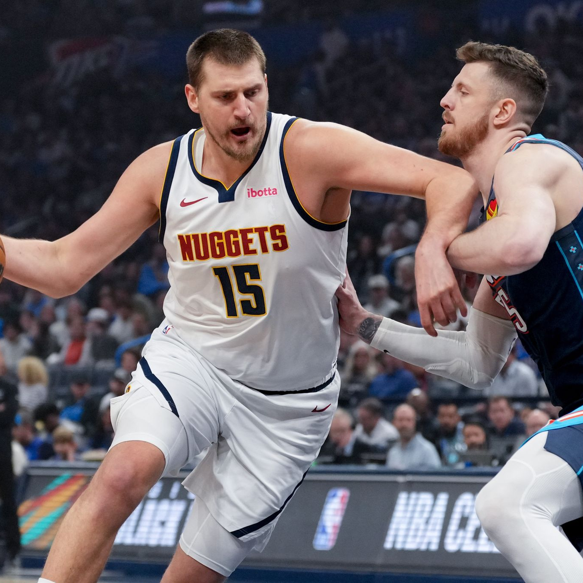 Schenkten sich in einer hitzigen Partie nichts: Nikola Jokic (l) und Isaiah Hartenstein. - Foto: Kyle Phillips/AP/dpa