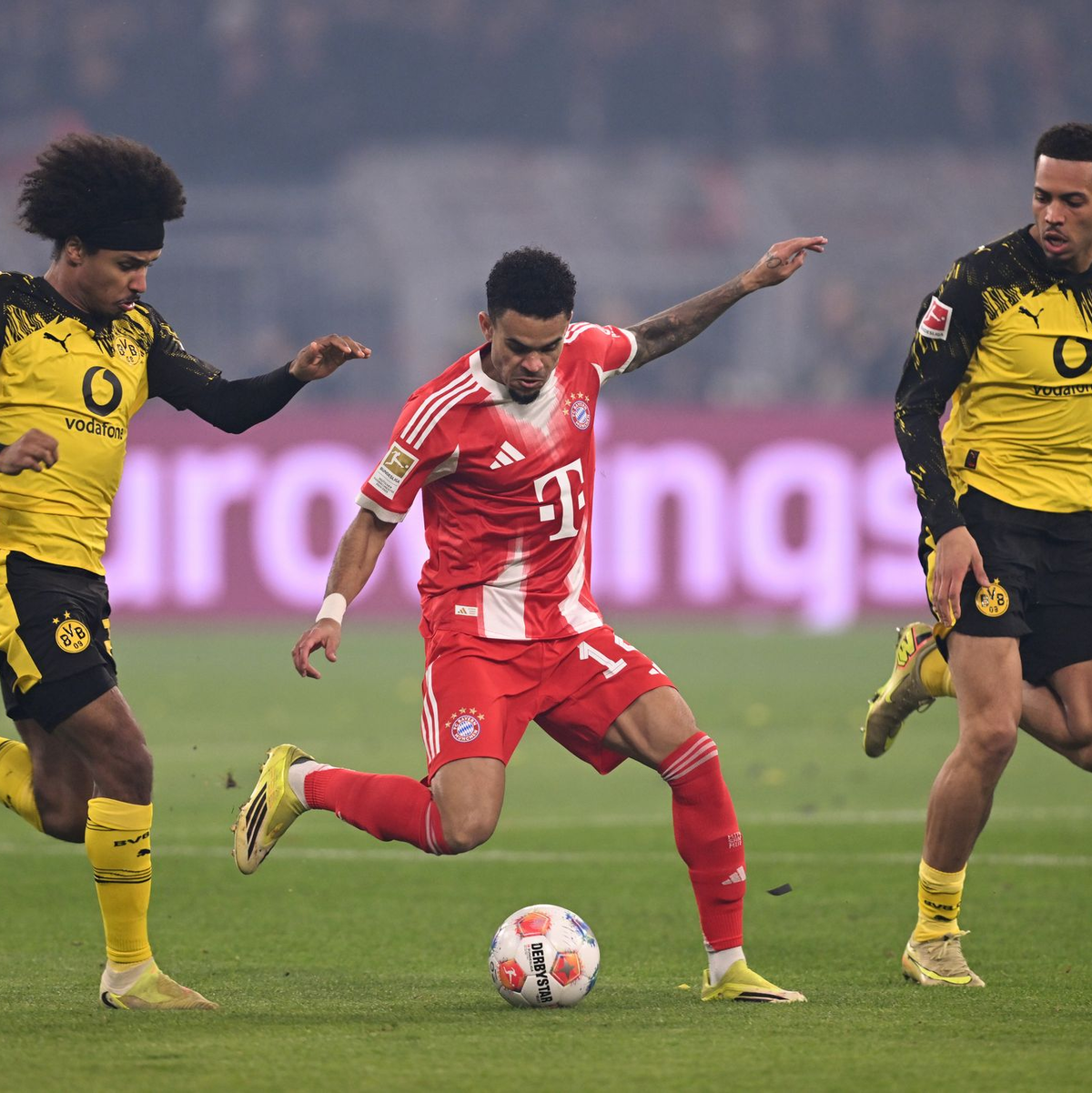 Luis Díaz umzingelt von zwei Dortmundern. - Foto: David Inderlied/dpa