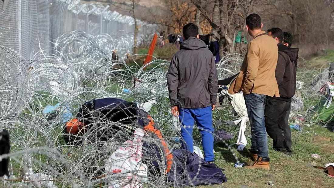 Flüchtlinge auf der Balkanroute vor einem Grenzzaun (Archiv) - Bild: via dts Nachrichtenagentur