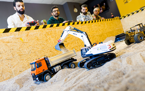 Gründer Siymo Othman (links) steuert mit Freunden kleine Bagger, Radlader und Lastwagen in seinem neu eröffneten Bagger-Café. Es soll das erste dieser Art in Deutschland sein. - Foto: Moritz Frankenberg/dpa Gründer Siymo Othman (links) steuert mit Freunden kleine Bagger, Radlader und Lastwagen in seinem neu eröffneten Bagger-Café. Es soll das erste dieser Art in Deutschland sein. - Foto: Moritz Frankenberg/dpa