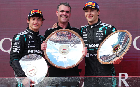 George Russell (r) freut sich über Silbergeschirr. - Foto: Scott Barbour/AP/dpa