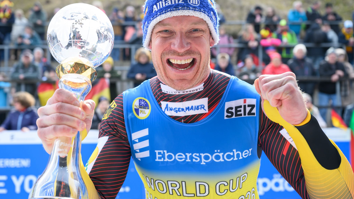 Felix Loch (Deutschland) jubelt mit der Kristallkugel für den Gesamtweltcup-Sieg. - Foto: Robert Michael/dpa