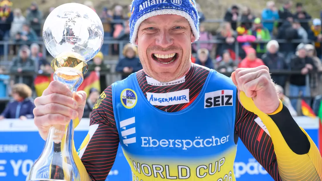 Felix Loch jubelt mit der Kristallkugel für den Gesamtweltcupsieg. - Bild: Robert Michael/dpa