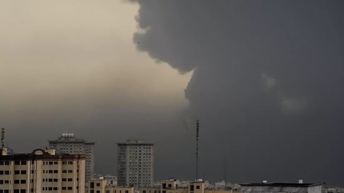 Am Morgen nach dem Angriff auf ein Öllager verdunkeln Rauchschwaden den wolkenverhangenen Himmel über Teheran.  - Bild: Vahid Salemi/AP/dpa