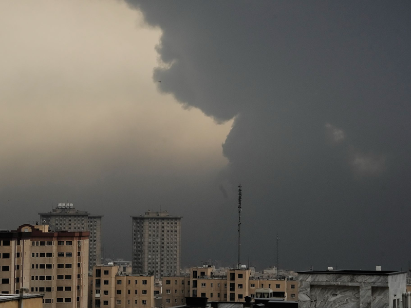 Am Morgen nach dem Angriff auf ein Öllager verdunkeln Rauchschwaden den wolkenverhangenen Himmel über Teheran.  - Foto: Vahid Salemi/AP/dpa