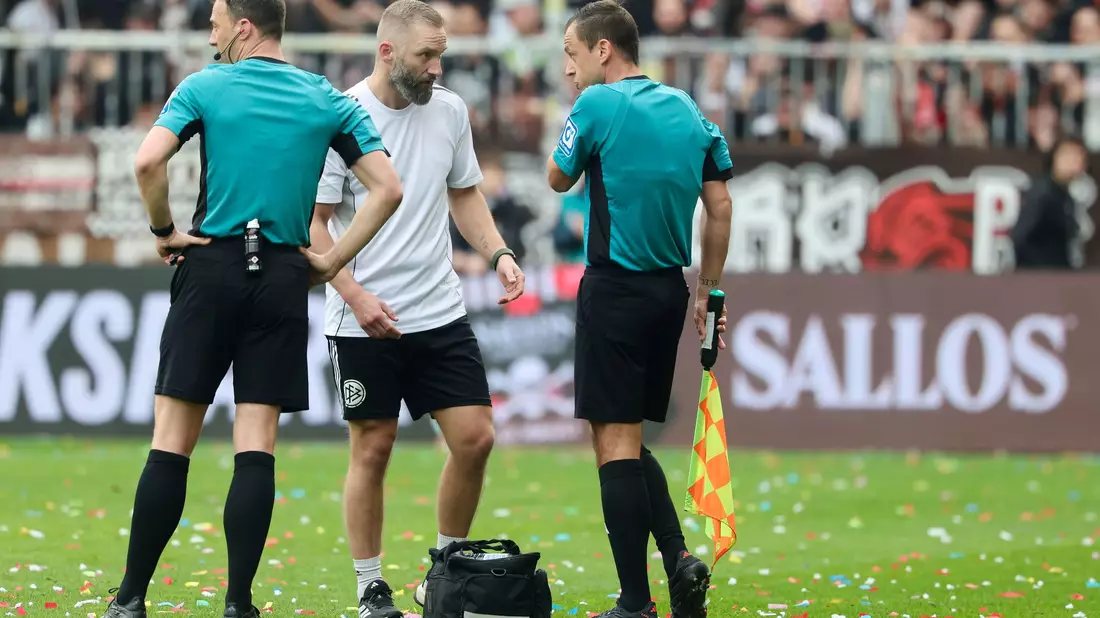 Musste verletzt ausgewechselt werden: Schiedsrichter-Assistent Christian Dietz (r). - Bild: Frank Molter/dpa