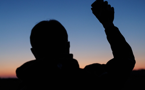 Umweltwissenschaftler Marcel Holy hält einen Lautsprecher in die Höhe. Der aufgezeichnete Revierruf des männlichen Rebhuhnes soll die echten Hähne dazu bringen, lautstark zu antworten. So können die Wildvögel gezählt werden.  - Foto: David Ebener/dpa