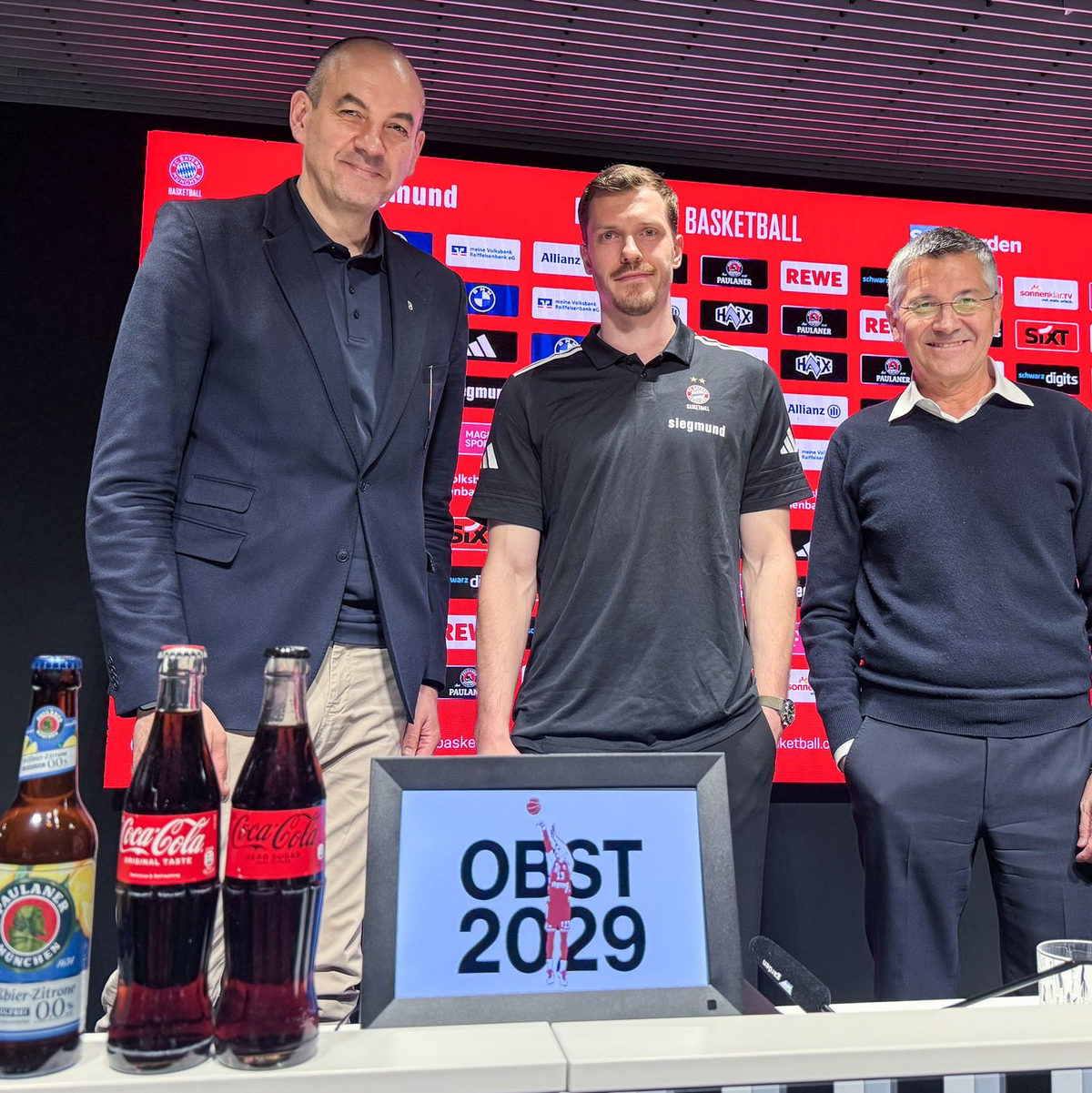 Andreas Obst (Mitte) nach seiner Vertragsverlängerung mit Bayern-Sportchef Dragan Tarlac (links) und Präsident Herbert Hainer. - Foto: Manuel Schwarz/dpa