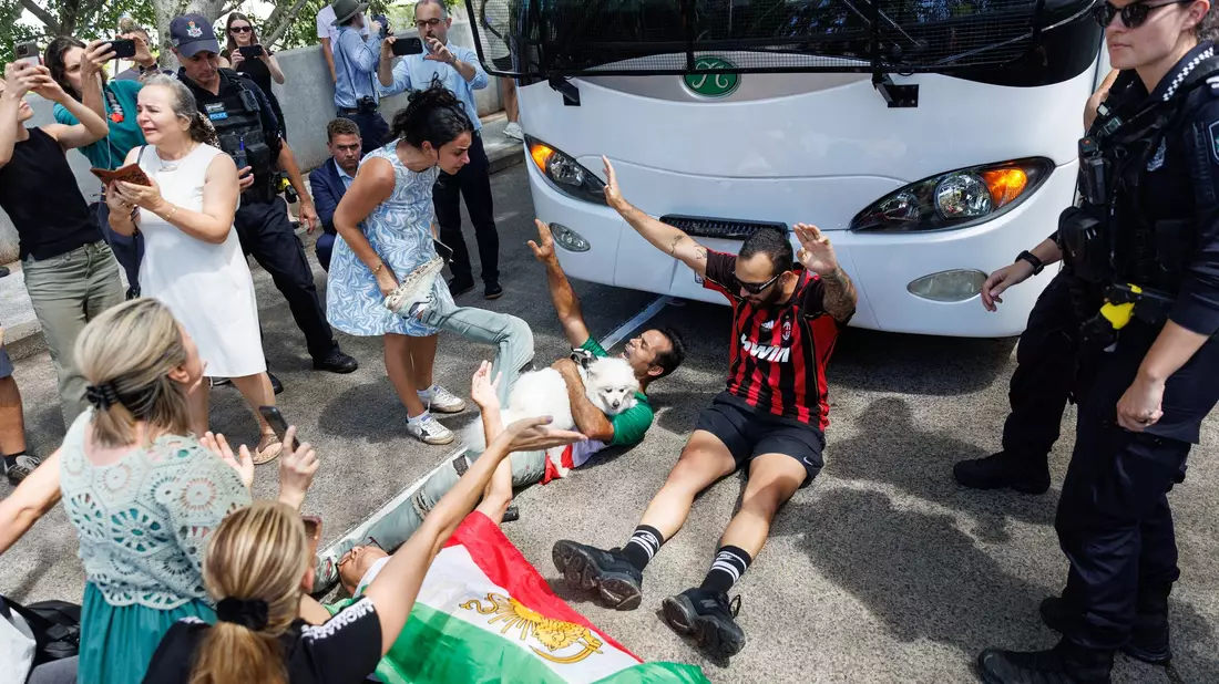 Demonstranten protestierten, während der Bus mit iranischen Spielerinnen und Mitarbeitern abfuhr. - Bild: Russell Freeman/AAP/dpa