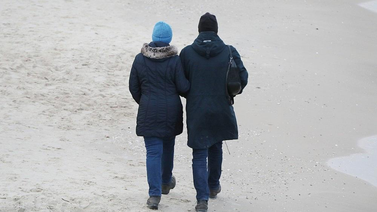 Paar geht am Strand spazieren - Foto: via dts Nachrichtenagentur