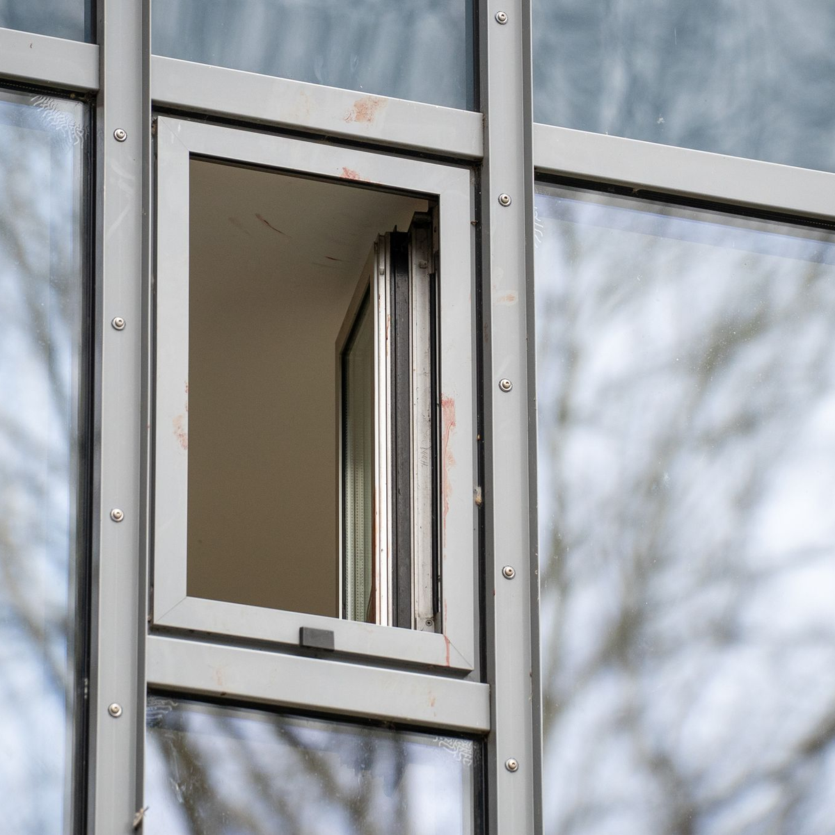 Ein blutverschmiertes Fenster in einem Hotel in Werne, in dem eine Frau erstochen wurde. - Foto: Max Lametz/dpa