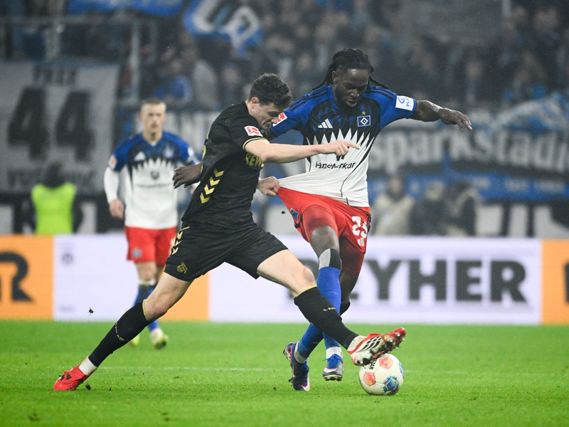 Kölns Eric Martel (l-r) und HSV-Abwehrspieler Jordan Torunarigha kämpfen um den Ball. - Foto: Gregor Fischer/dpa