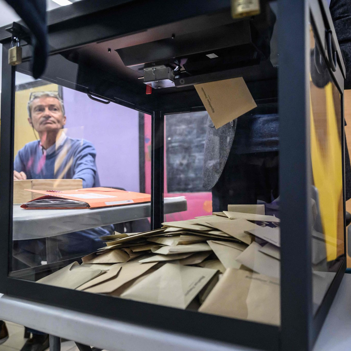 Ein Beamter beobachtet, wie Wähler während der ersten Runde der französischen Kommunalwahlen 2026 in Perpignan, Südfrankreich, ihre Stimme abgeben. - Foto: Ed Jones/AFP/dpa