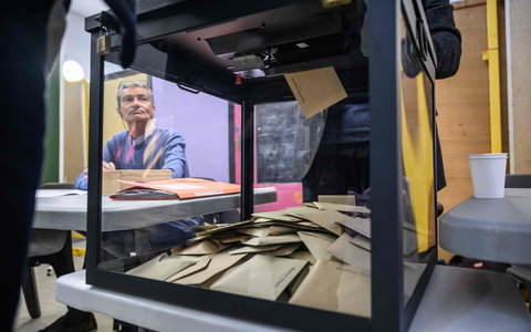 Ein Beamter beobachtet, wie Wähler während der ersten Runde der französischen Kommunalwahlen 2026 in Perpignan, Südfrankreich, ihre Stimme abgeben. - Foto: Ed Jones/AFP/dpa