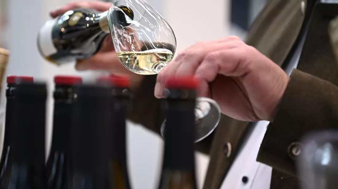 Ein Mitarbeiter des badischen Weinguts Bimmerle gießt am Prowein-Messe-Stand seiner Firma Riesling in ein Glas. - Bild: Wolf von Dewitz/dpa