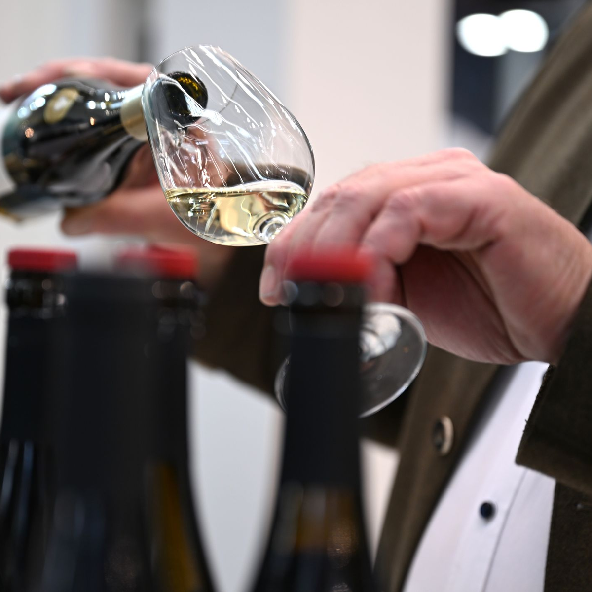 Ein Mitarbeiter des badischen Weinguts Bimmerle gießt am Prowein-Messe-Stand seiner Firma Riesling in ein Glas. - Foto: Wolf von Dewitz/dpa