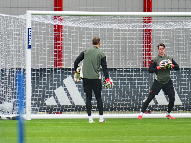 Jonas Urbig beim Abschlusstraining in Aktion, links Manuel Neuer. - Foto: Malin Wunderlich/dpa