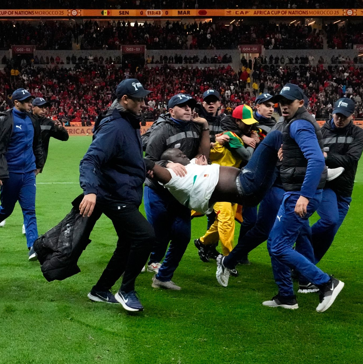 Ein auf den Platz gestürmter Anhänger des Senegals wurde von Sicherheitskräften weggetragen. (Archivbild) - Foto: Themba Hadebe/AP/dpa