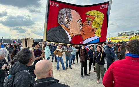 Demonstranten halten bei einer Kundgebung des Bündnisses «Eine Million Augenblicke für Demokratie» ein Banner, auf dem sich stilisiert US-Präsident Trump und Russlands Präsident Putin küssen. - Foto: Michael Heitmann/dpa
