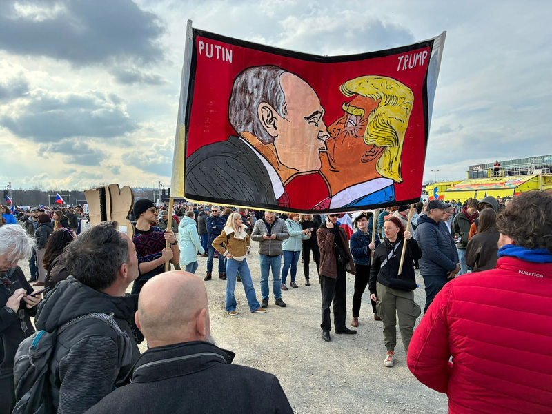 Demonstranten halten bei einer Kundgebung des Bündnisses «Eine Million Augenblicke für Demokratie» ein Banner, auf dem sich stilisiert US-Präsident Trump und Russlands Präsident Putin küssen. - Foto: Michael Heitmann/dpa