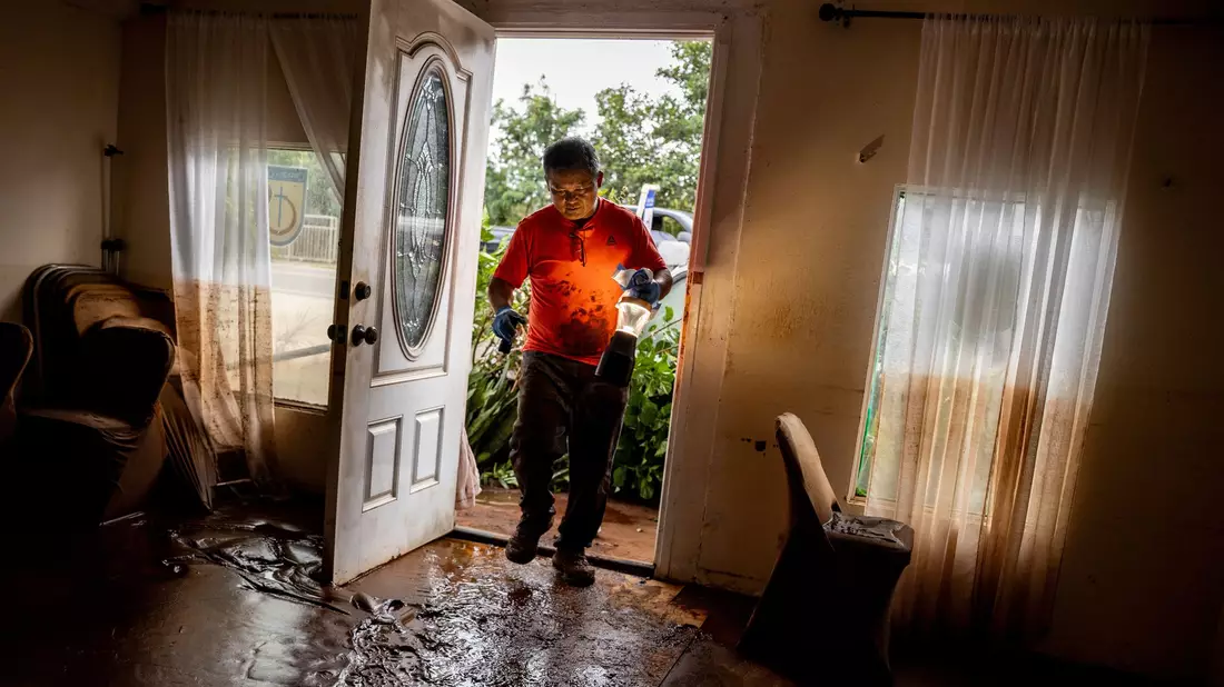 Glenn Duquez, stellvertretender Pastor der Church of God Jesus is Alive Fellowship, trägt eine Lampe in das schlammdurchtränkte Kirchengebäude, um nach der Flut aufzuräumen. - Bild: Stephen Lam/San Francisco Chronicle via AP/dpa
