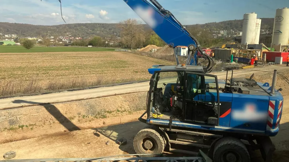 Der beschädigte Bagger steht an einer Baustelle neben den Bahngleisen. - Bild: Privat/dpa