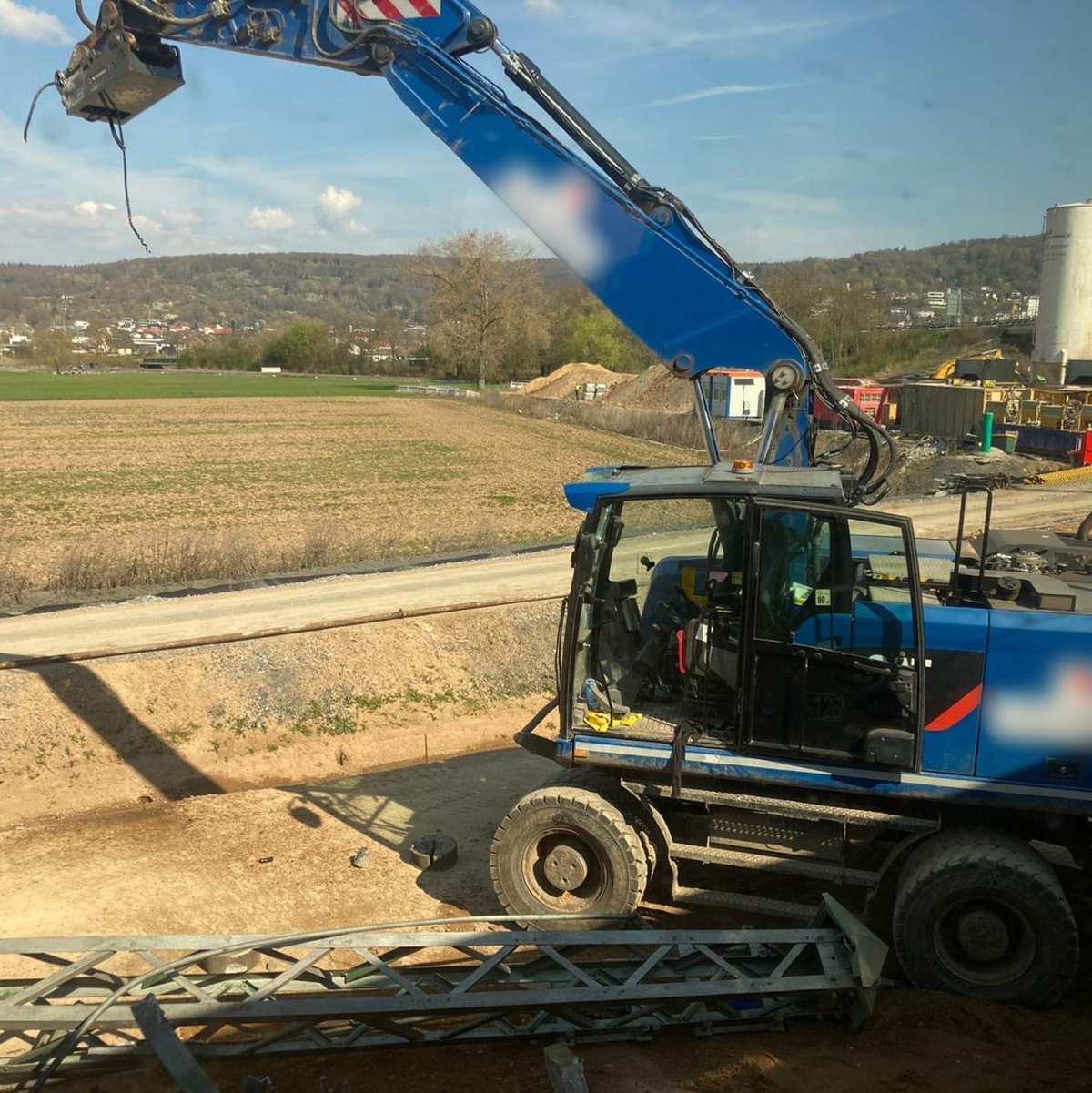 Der beschädigte Bagger steht an einer Baustelle neben den Bahngleisen. - Foto: Privat/dpa