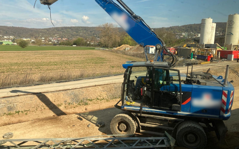Der beschädigte Bagger steht an einer Baustelle neben den Bahngleisen. - Foto: Privat/dpa