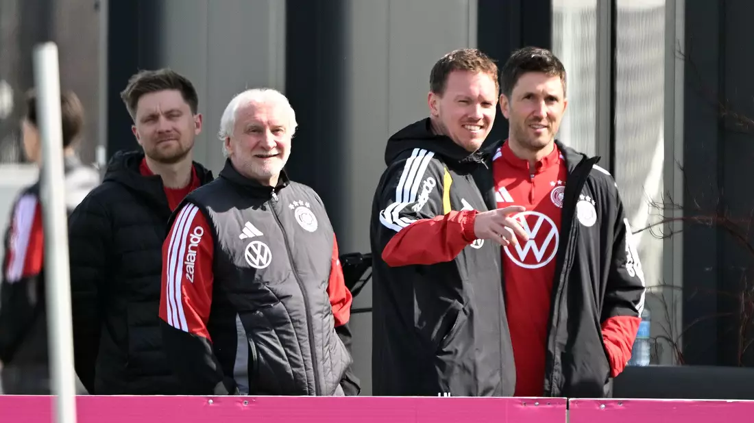 Rudi Völler (l.) und Julian Nagelsmann (2.v.r.) schauen auf den Trainingsplatz.  - Bild: Federico Gambarini/dpa