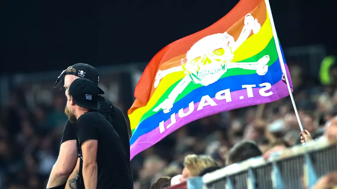 Fans des FC St. Pauli mit der Regenbogenfahne, die weltweit als Symbol für Vielfalt, Toleranz und Akzeptanz steht. (Archivbild) - Bild: Christian Charisius/dpa