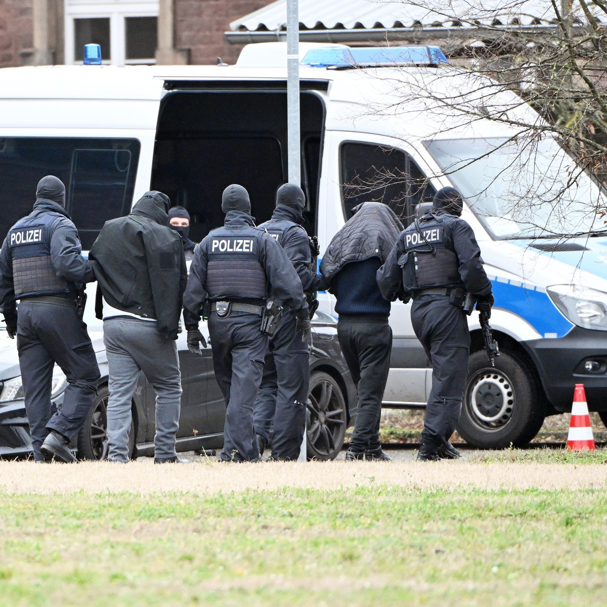 Zwei mutmaßliche Hamas-Mitglieder werden von Polizisten bei einem Hubschrauberlandeplatz von einem Hubschrauber zu einem Auto geführt. (Archivbild) - Foto: Uli Deck/dpa